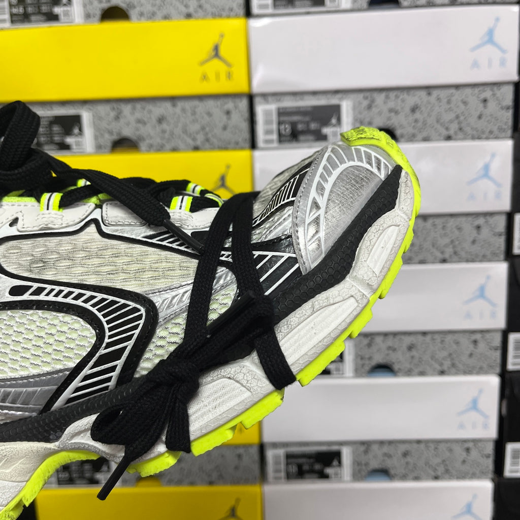 Silver running sneaker side panel with black laces and neon green trim