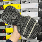 Outsole of light gray unisex sneakers with deep grid tread pattern