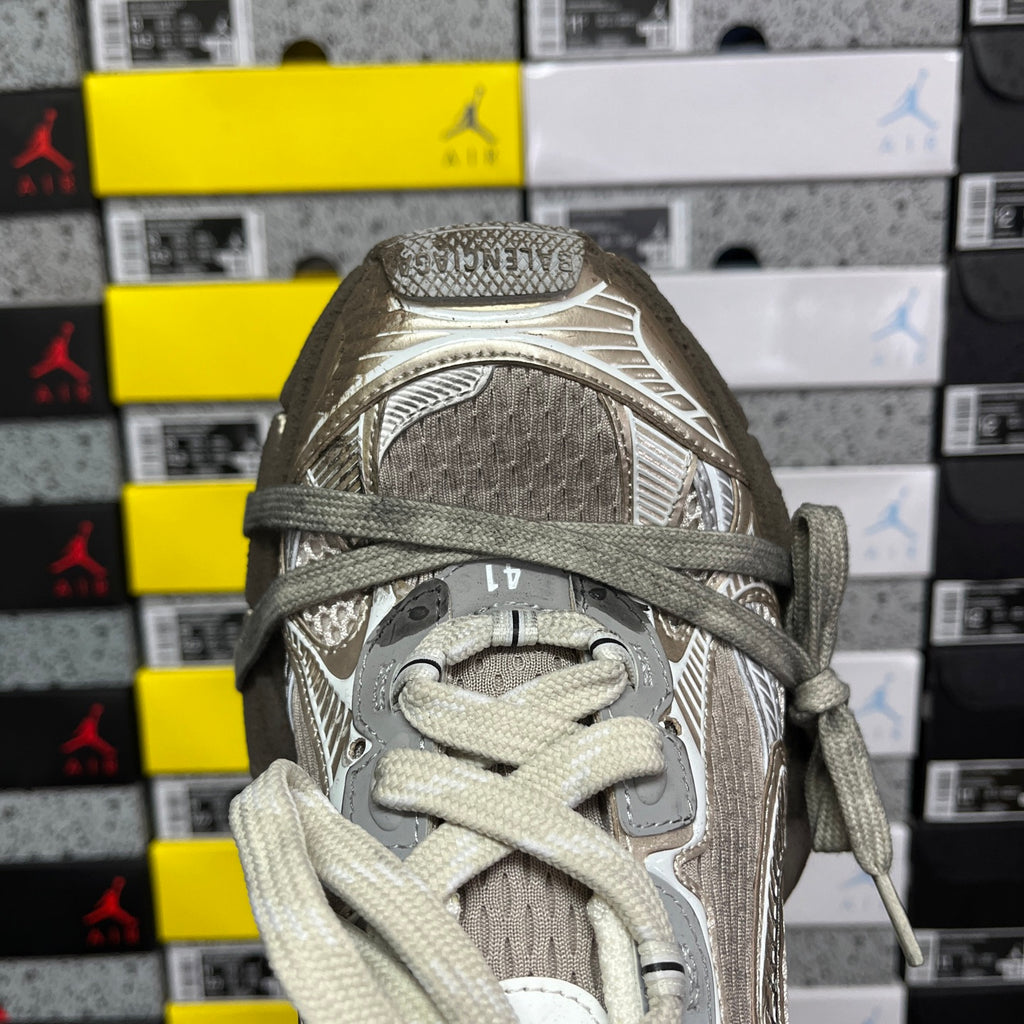 Light gray sneaker toe and lace area with textured mesh upper and metal accents