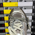 Light gray sneaker toe and lace area with textured mesh upper and metal accents