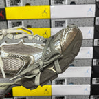 Light gray unisex sneakers, heel and side details with metallic trim and laces