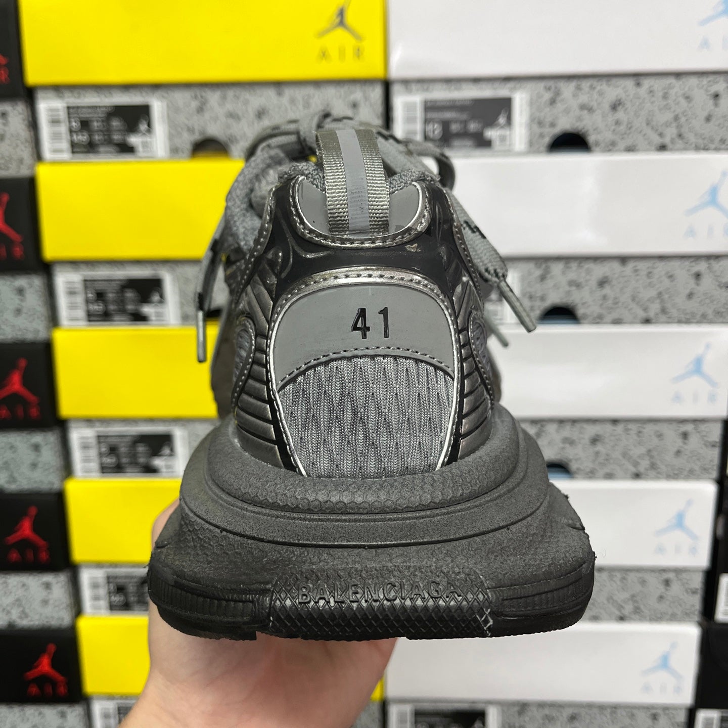 Unisex gray sneaker heel view with logo patch and thick cushioned sole