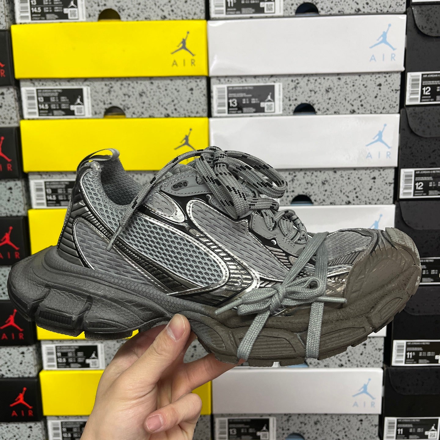 Unisex gray athletic sneaker with lace-up front and textured side panel