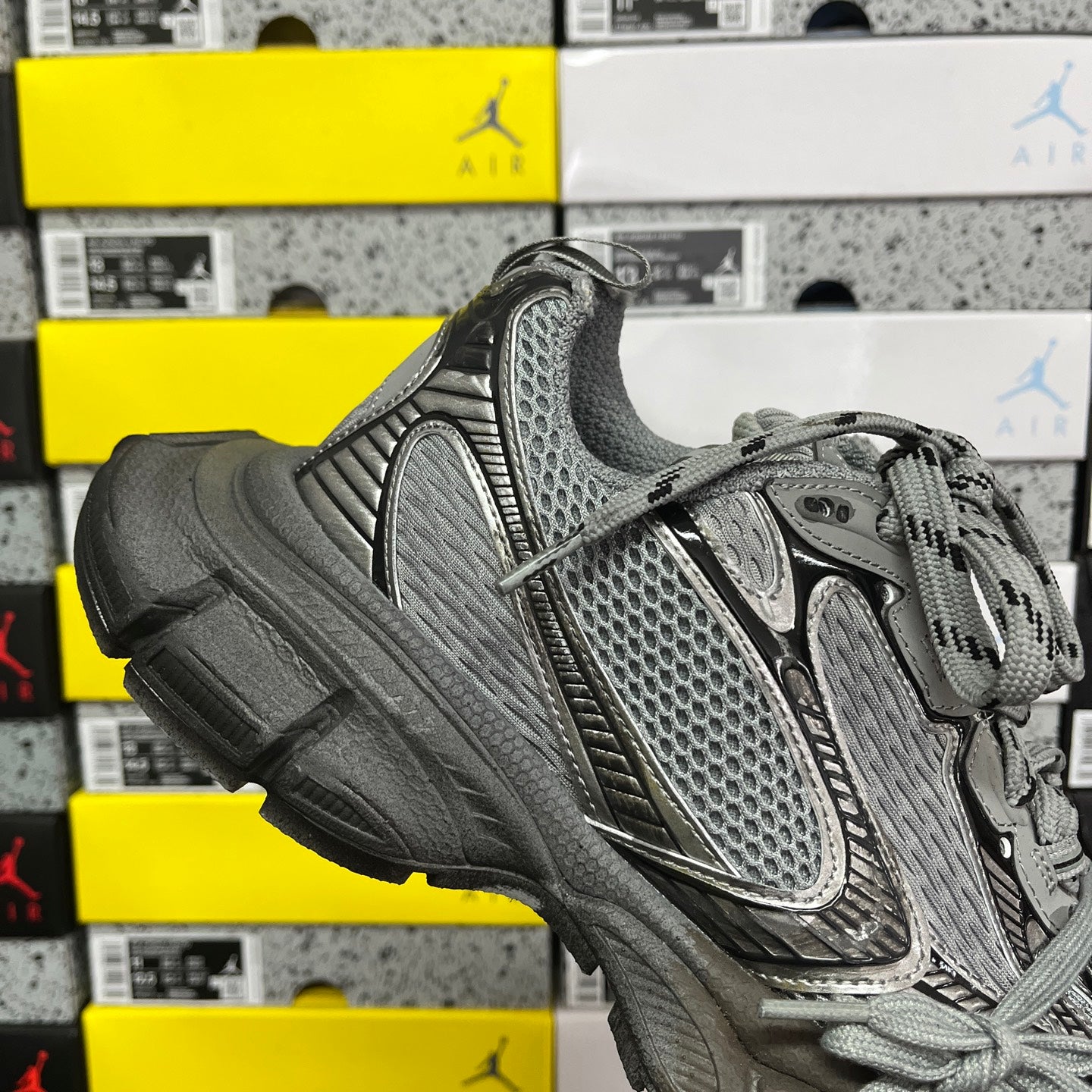 Unisex gray sneaker front with perforated mesh upper and lace-up design