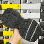 Unisex gray sneaker outsole view with tread pattern and lace strap detail