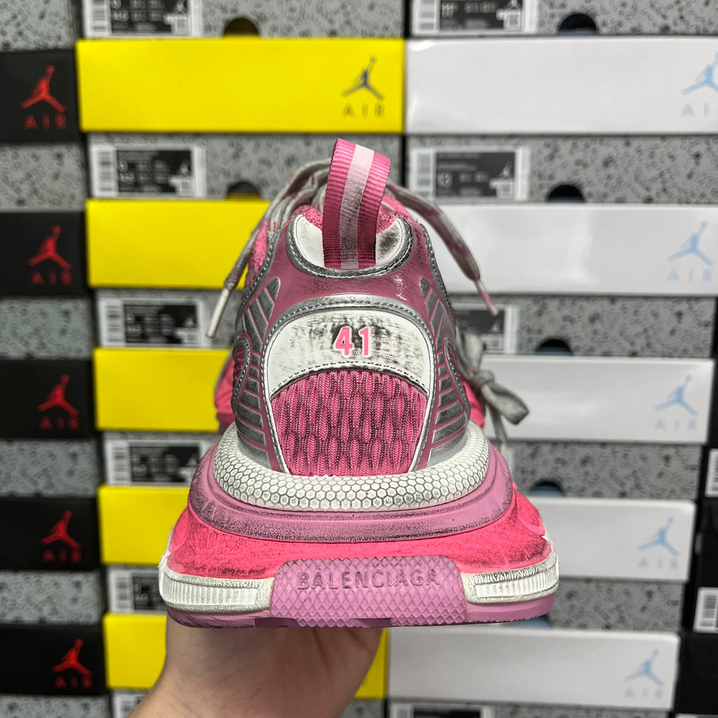 Pink running sneakers heel with white logo patch and gray braided laces