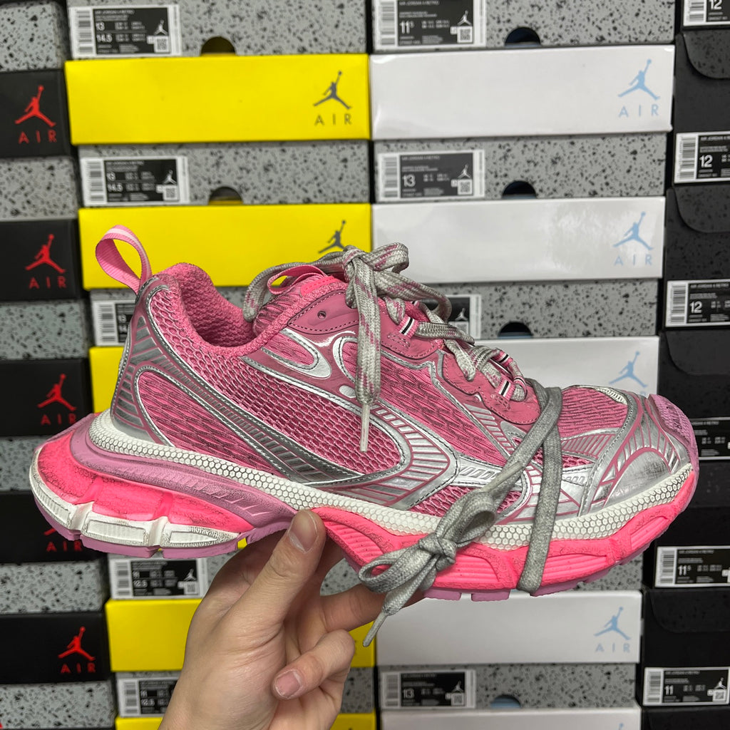 Pink and gray lace-up running sneakers with silver logo and textured sole