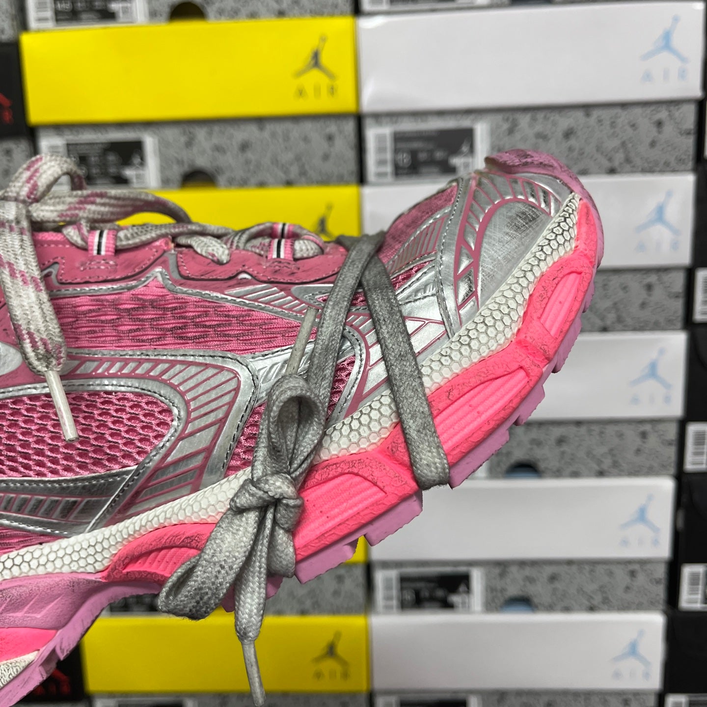 Pink and gray running sneakers with gray laces and textured heel detail