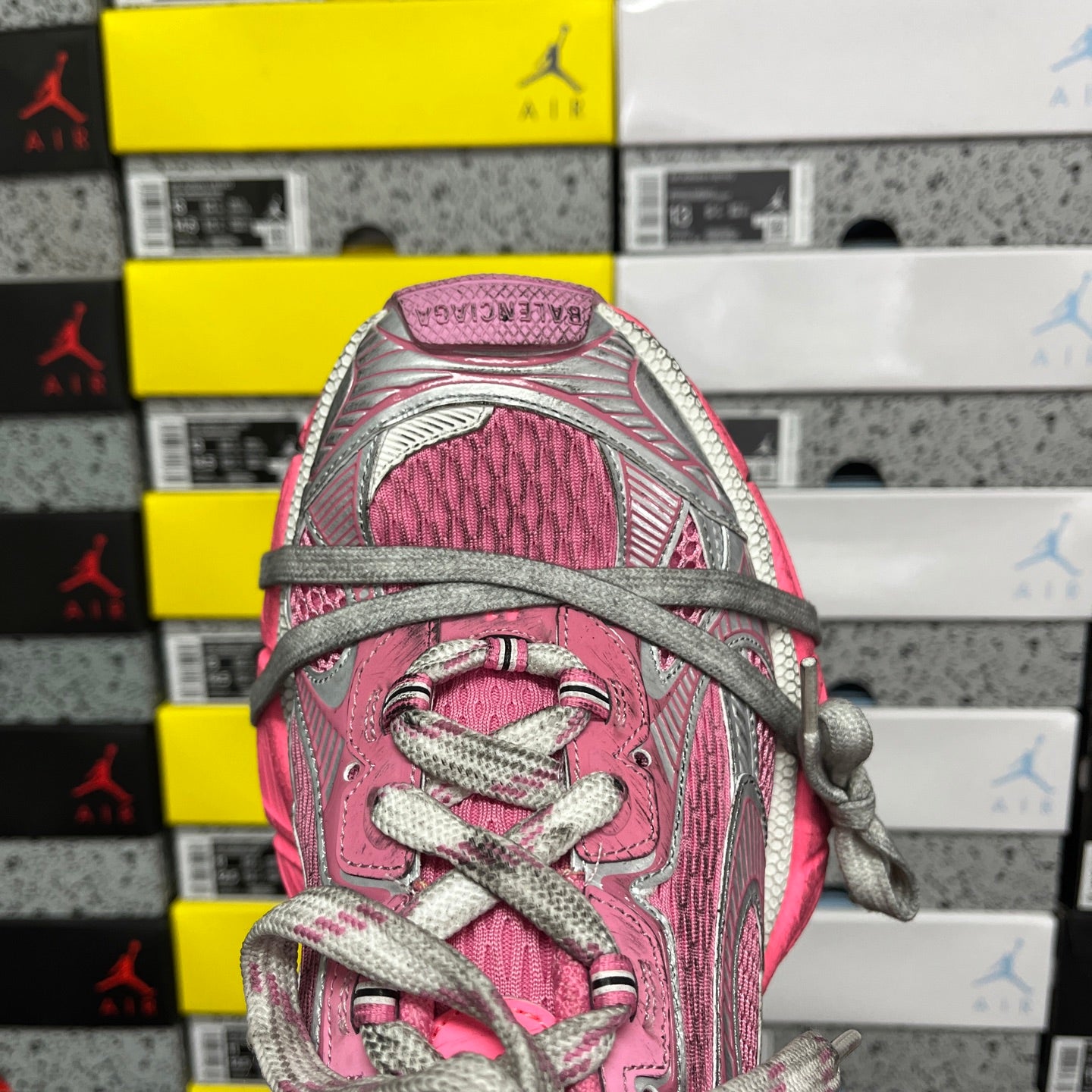 Pink knit sneaker tongue and lace area with gray eyelets and woven laces