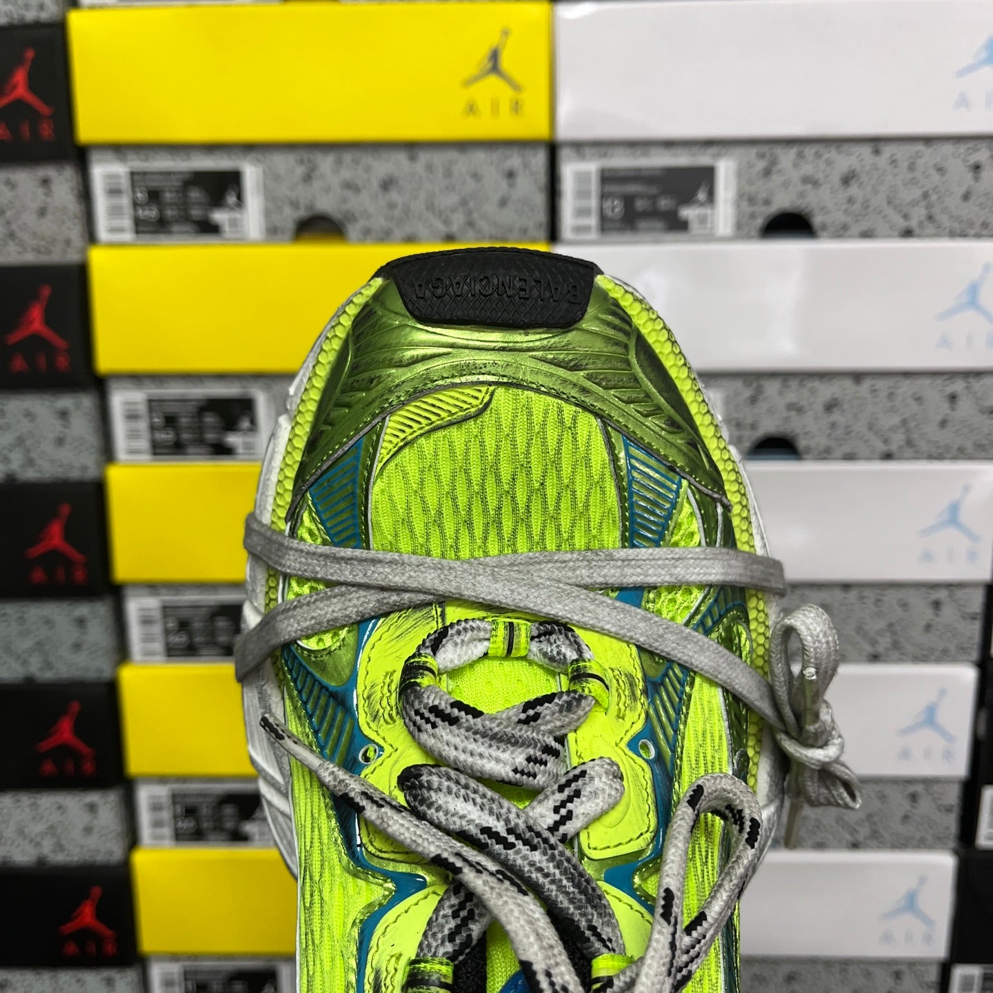 Close-up of neon green and blue shoe upper with gray laces and textured panel