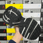 Black outsole with white traction stripes of neon green and blue running shoe