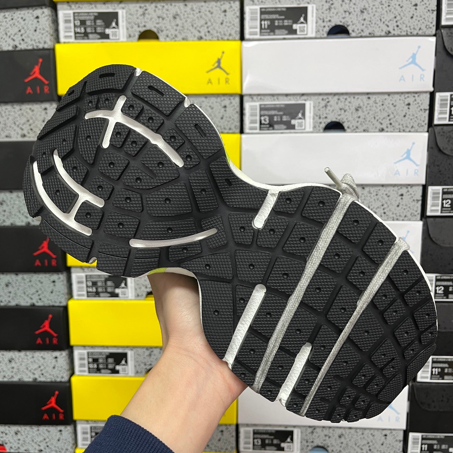 Black outsole with white traction stripes of neon green and blue running shoe