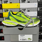 Neon green and blue lace-up running shoe on gray box, with chunky white midsole