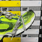 Side view of neon green and blue lace-up running shoe with gray laces and sole