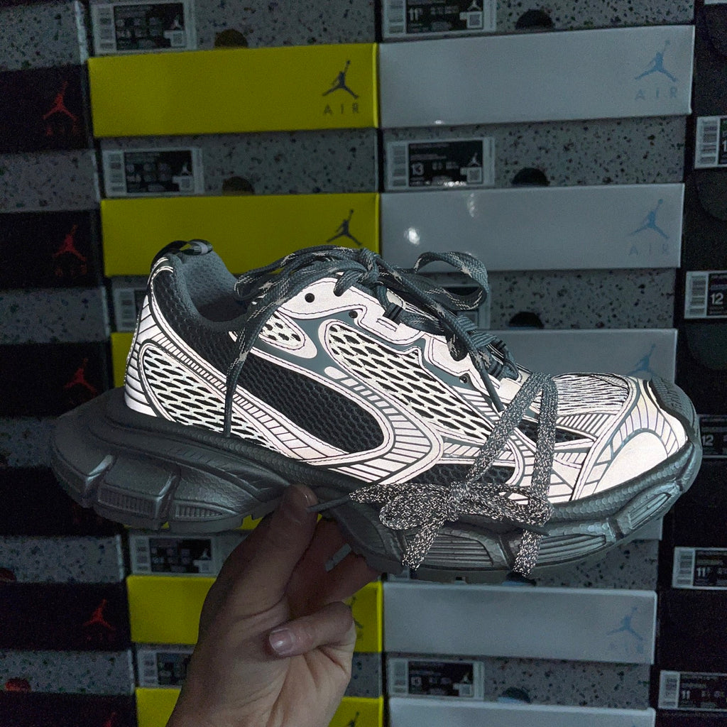Gray and dark lace-up sneakers with logo-like side panels and chunky sole