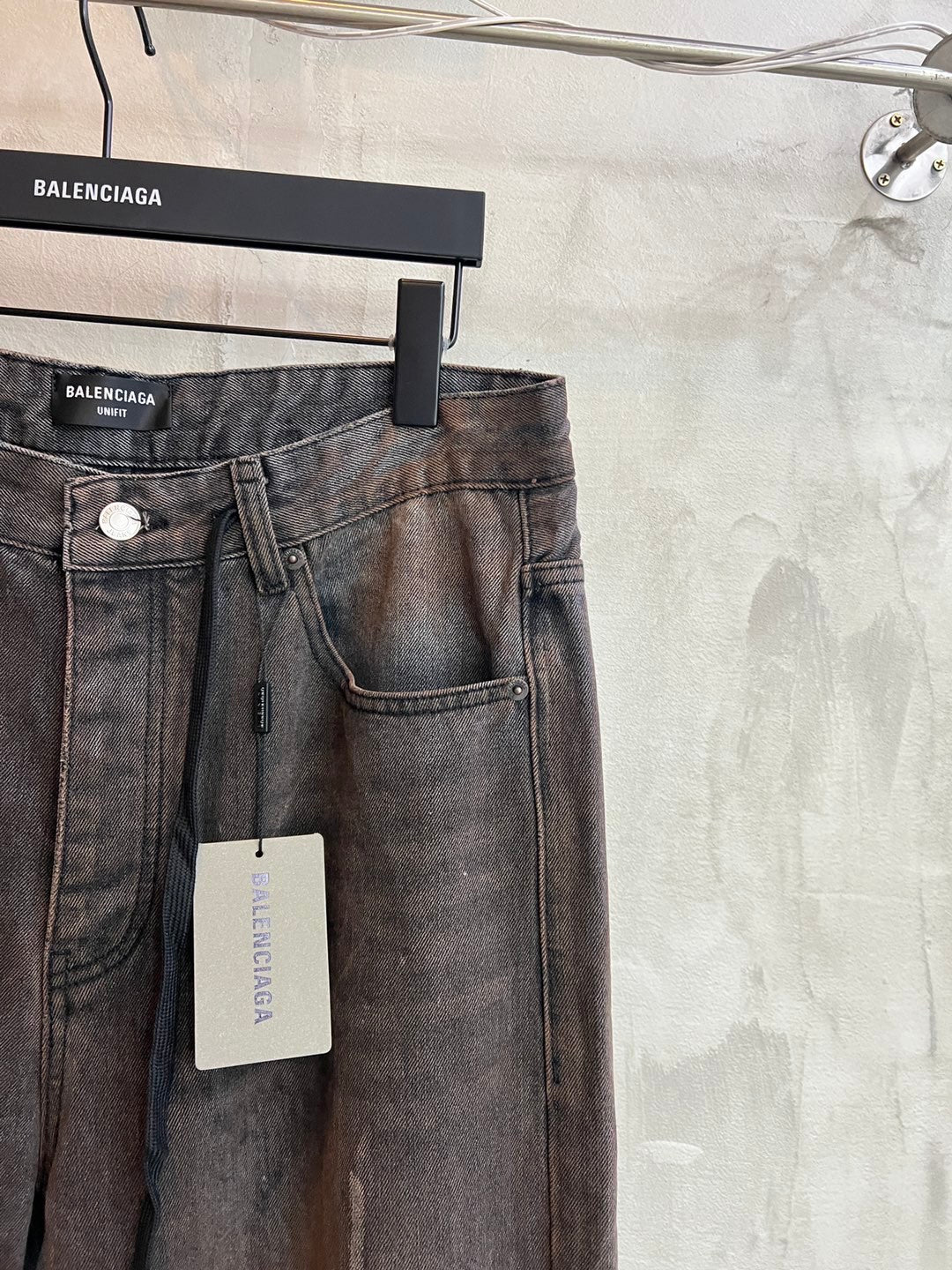 Balenciaga denim pants with front button, belt loops, and hanging size tag