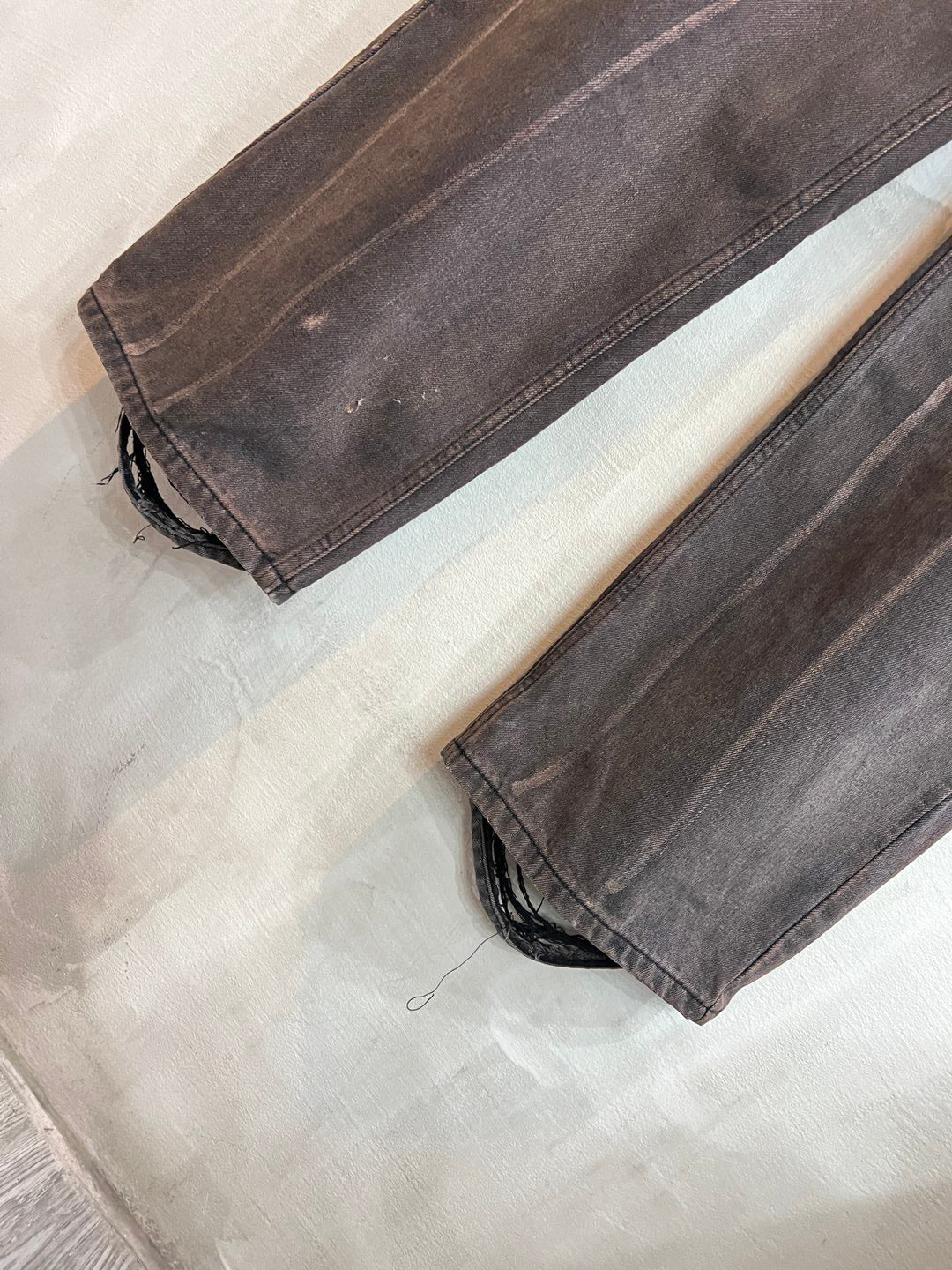 Balenciaga denim pants with frayed cuffs and distressed dark gray wash