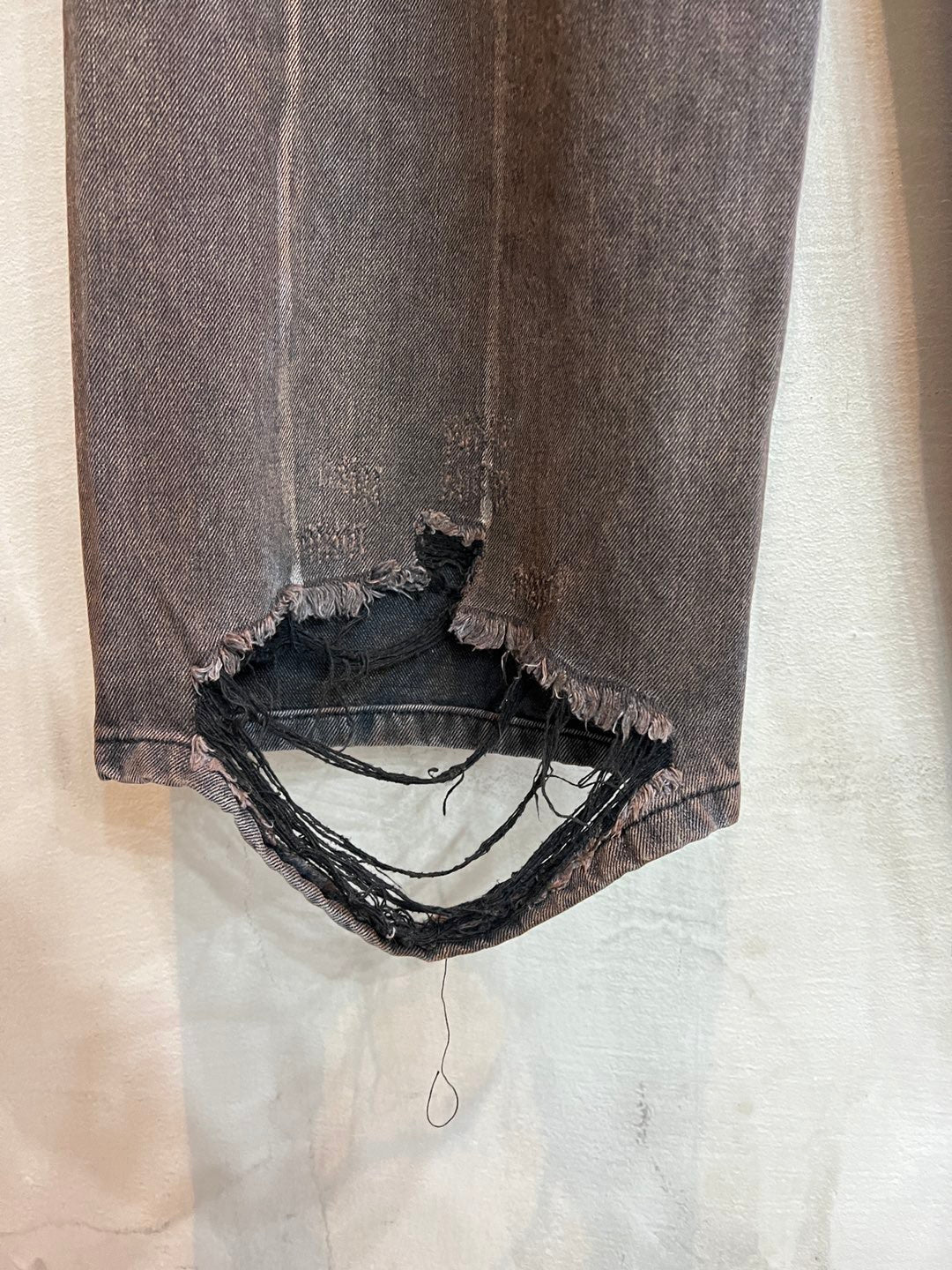 Balenciaga denim pants with frayed ankle cuffs and layered black trim