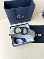 Dior belt on display, light gray logo strap with black CD buckle.