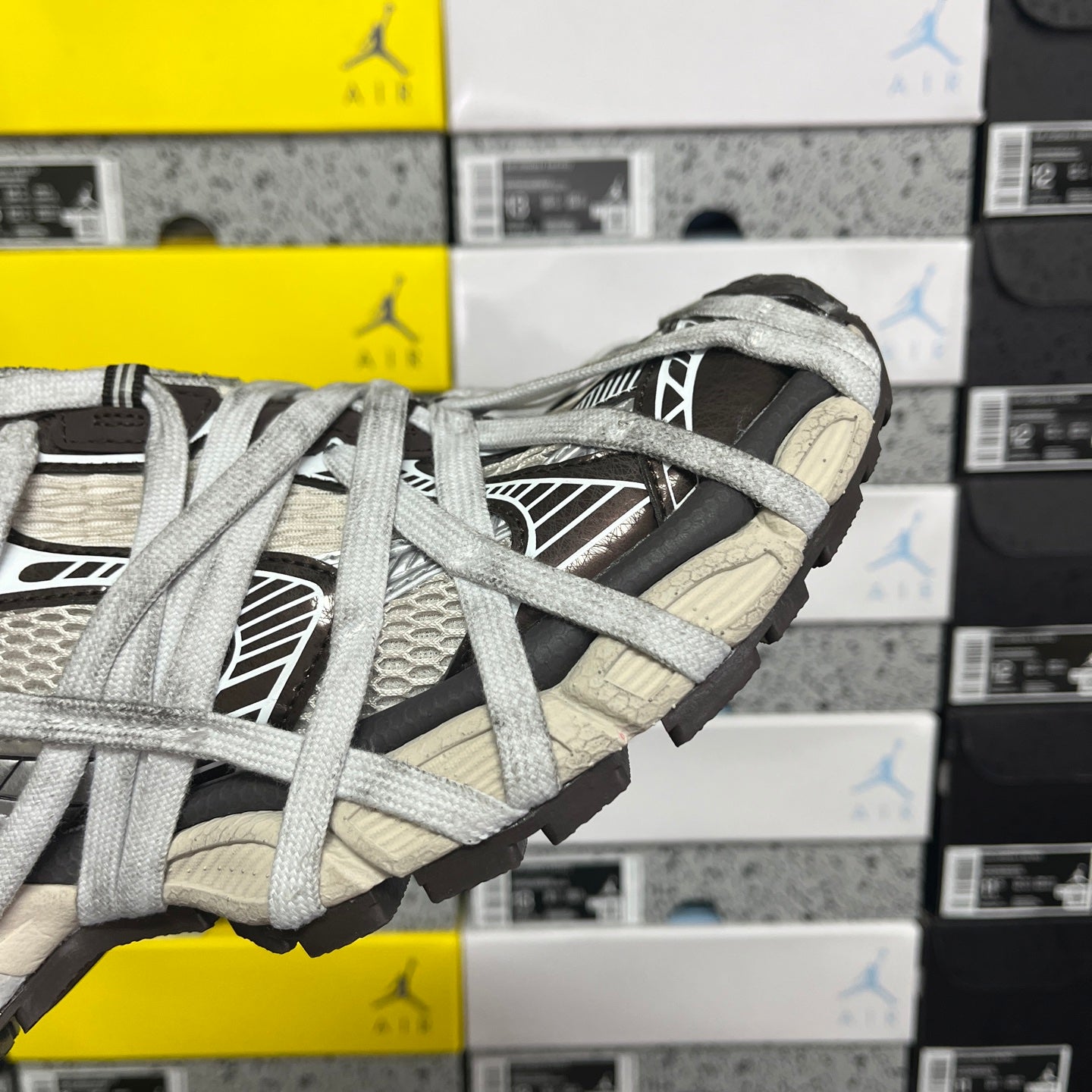 Unisex sneakers close-up of toe and lace-up front with gray and cream panels