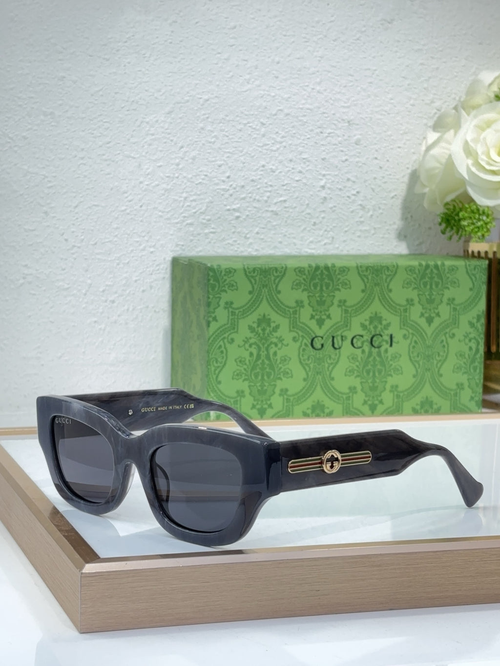 Black oversized sunglasses with dark lenses and gold logo bridge detail