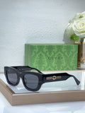 Black oversized sunglasses with dark lenses and gold logo bridge detail