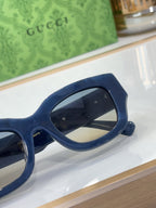 Navy blue eyeglasses with rounded frames and dark tinted lenses, side view