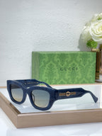 Navy blue oversized sunglasses with dark lenses and gold logo bridge detail