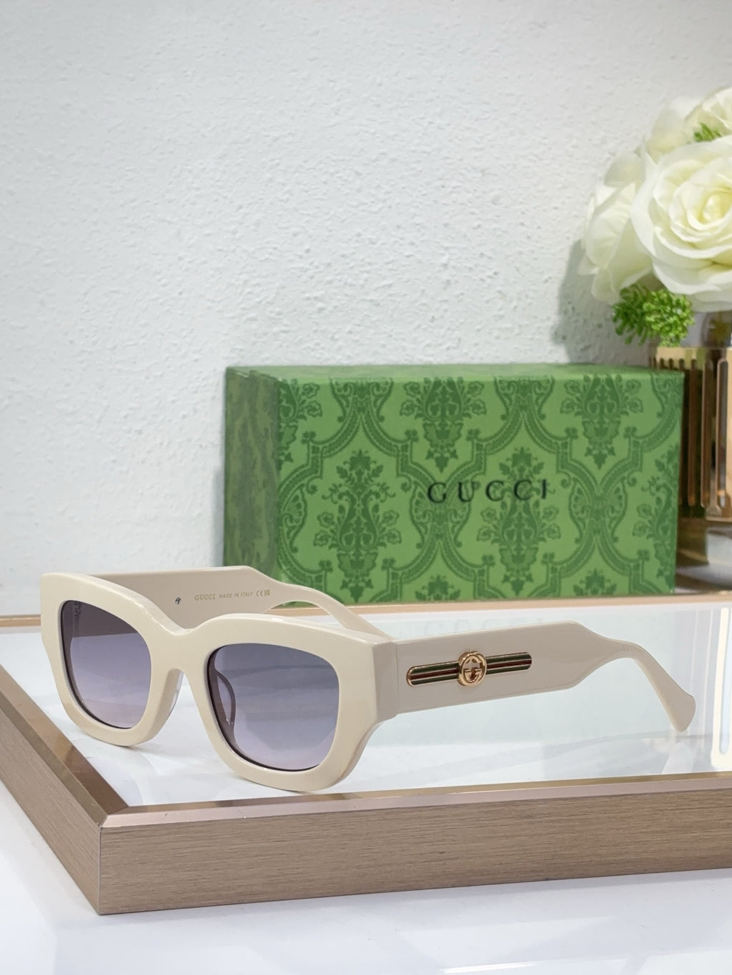 White oversized sunglasses with tinted lenses and gold logo bridge detail