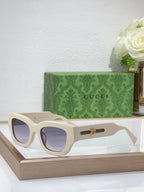 White oversized sunglasses with tinted lenses and gold logo bridge detail