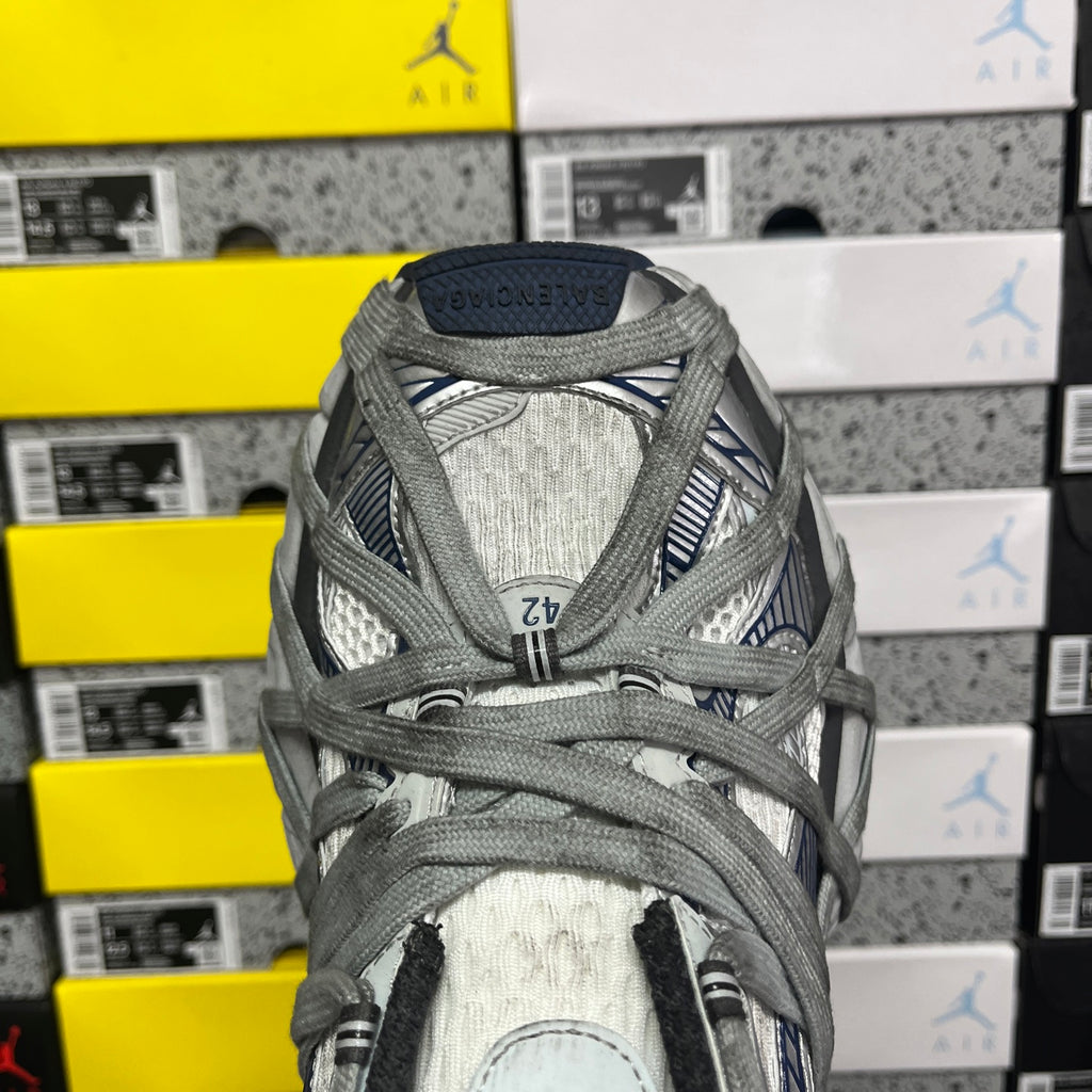 Balenciaga unisex sneaker front, grey textured knit upper with laces and blue logo stripe