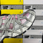 Light gray lace-up sneaker side profile with pink stripe details