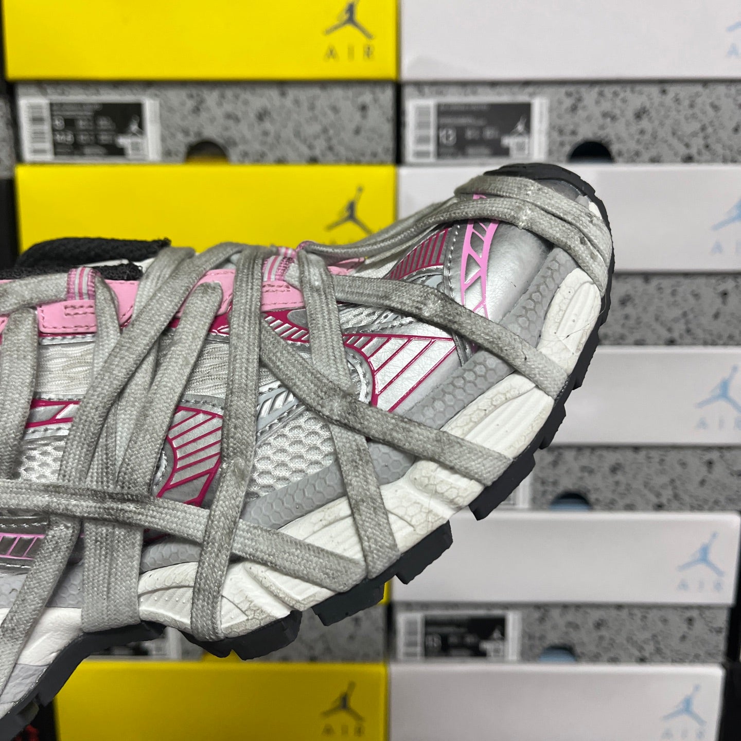 Light gray lace-up sneaker side profile with pink stripe details