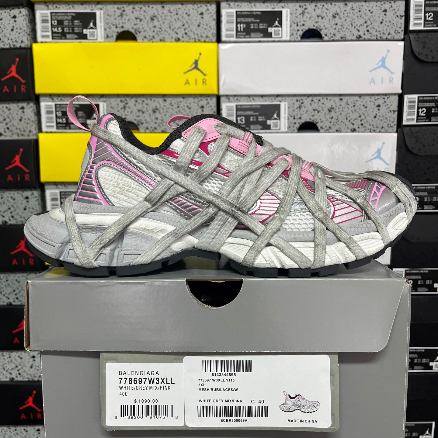 Light gray lace-up sneaker with pink stripe detailing on shoebox