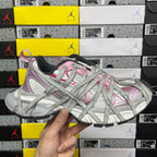 Light gray lace-up sneaker with pink accents and textured panels