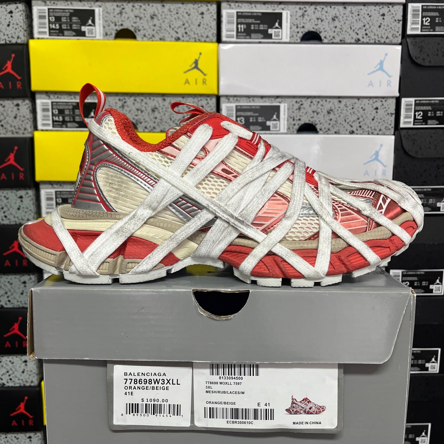 Red and white Balenciaga sneaker on shoebox, crisscross laces and mesh panels