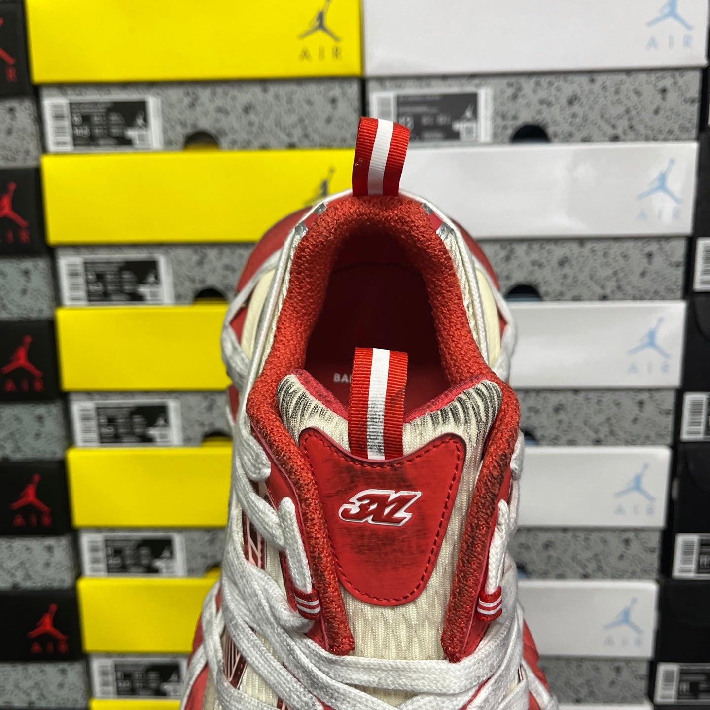 Balenciaga sneaker heel with red leather patch, woven sides, and striped pull tab
