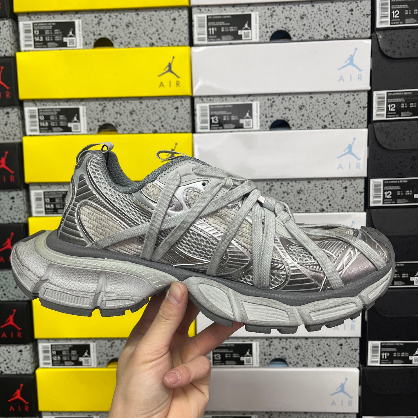 Gray lace-up sneaker in hand, side profile with thick sole