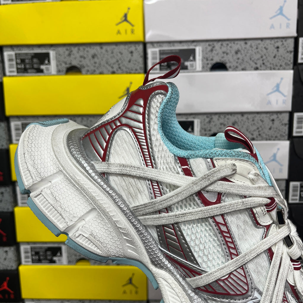 Front-side view of white lace-up sneaker with red accents and light blue collar lining