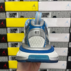 Heel view lace-up sneaker with blue back strap, gray outsole, and textured heel panel