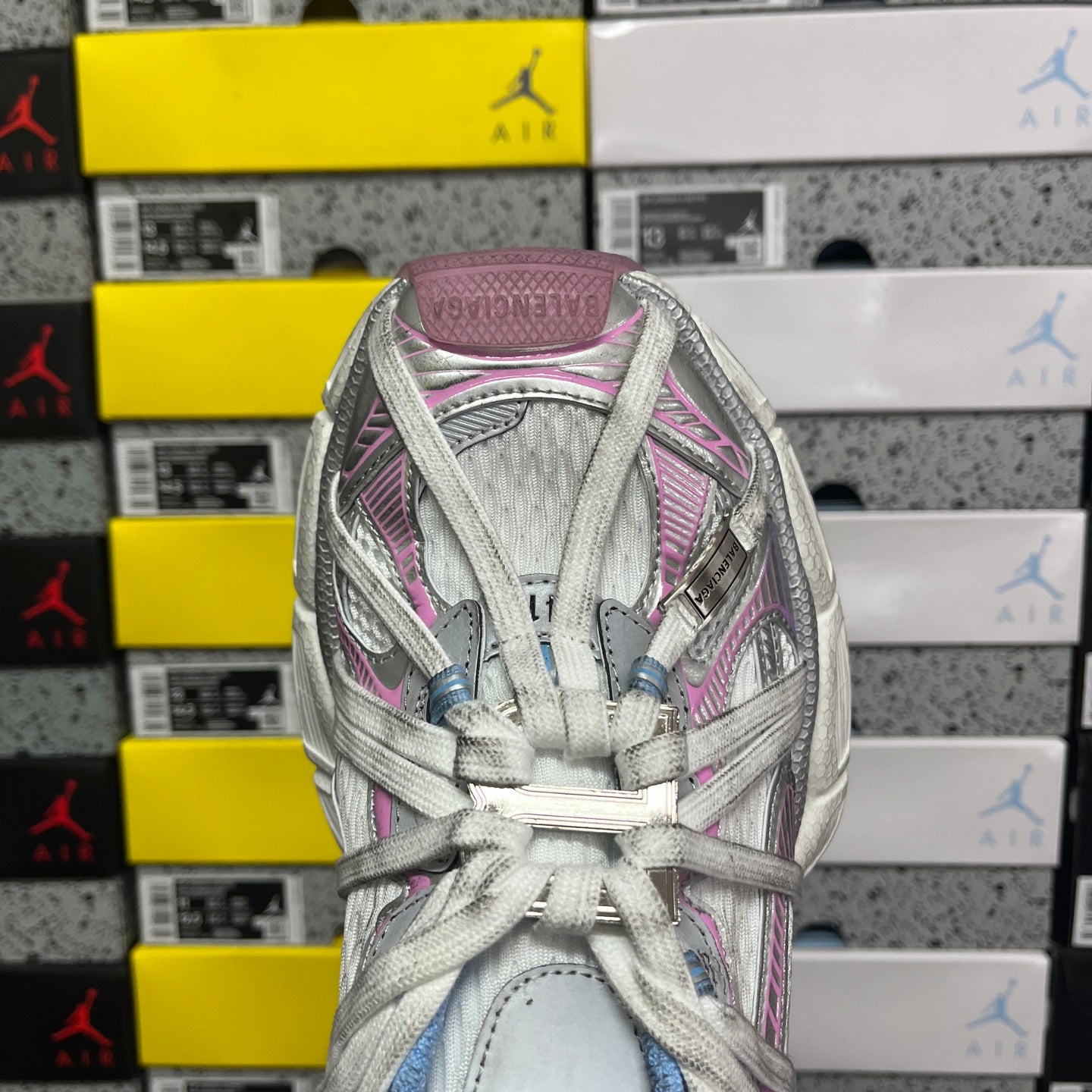 Back view lace-up sneaker with light gray upper, pink trim, and blue collar lining
