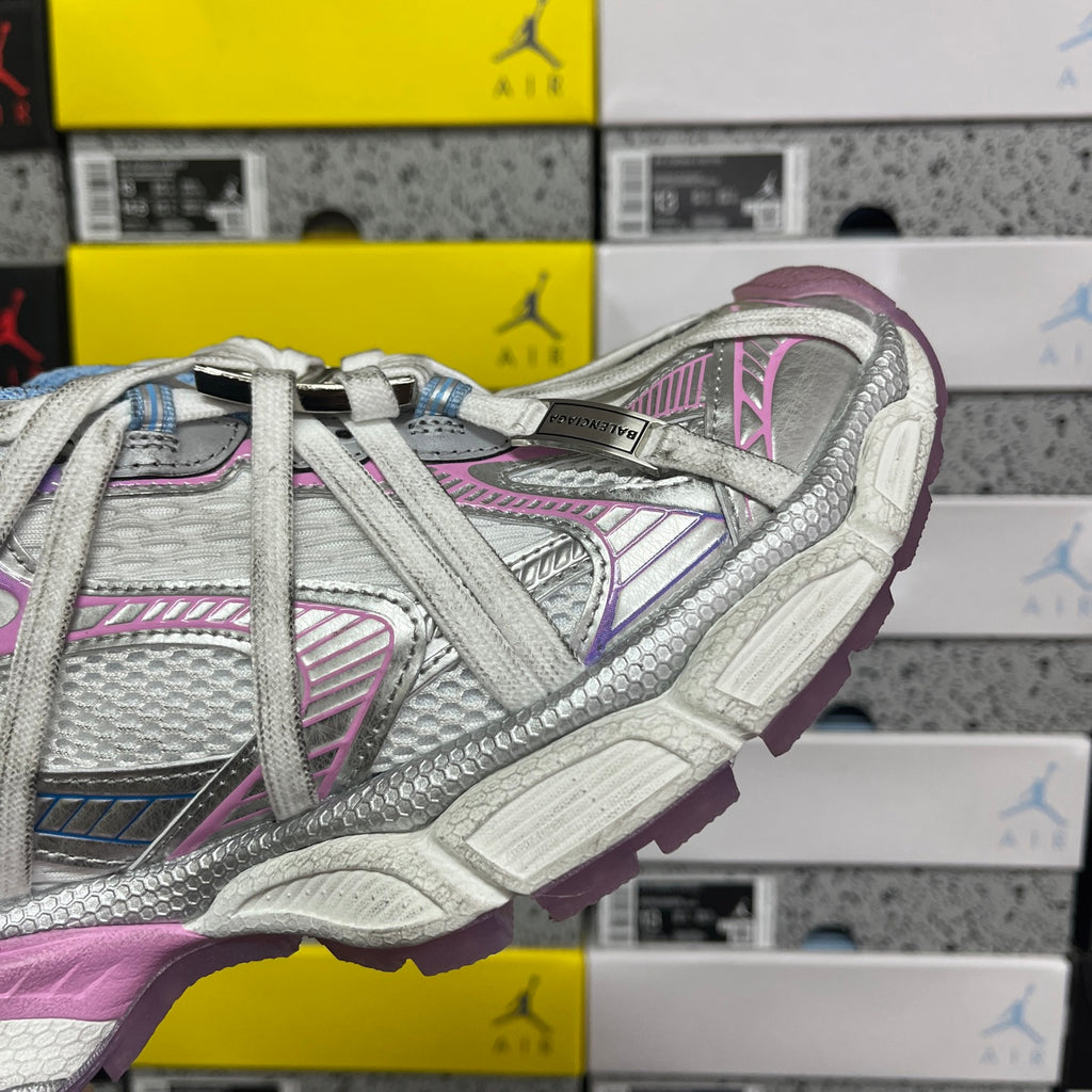 Side view lace-up sneaker with white, blue, and pink panel details and molded sole