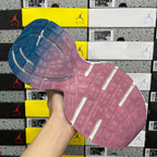 Sole of lace-up sneaker in pink with textured tread and blue outsole edge