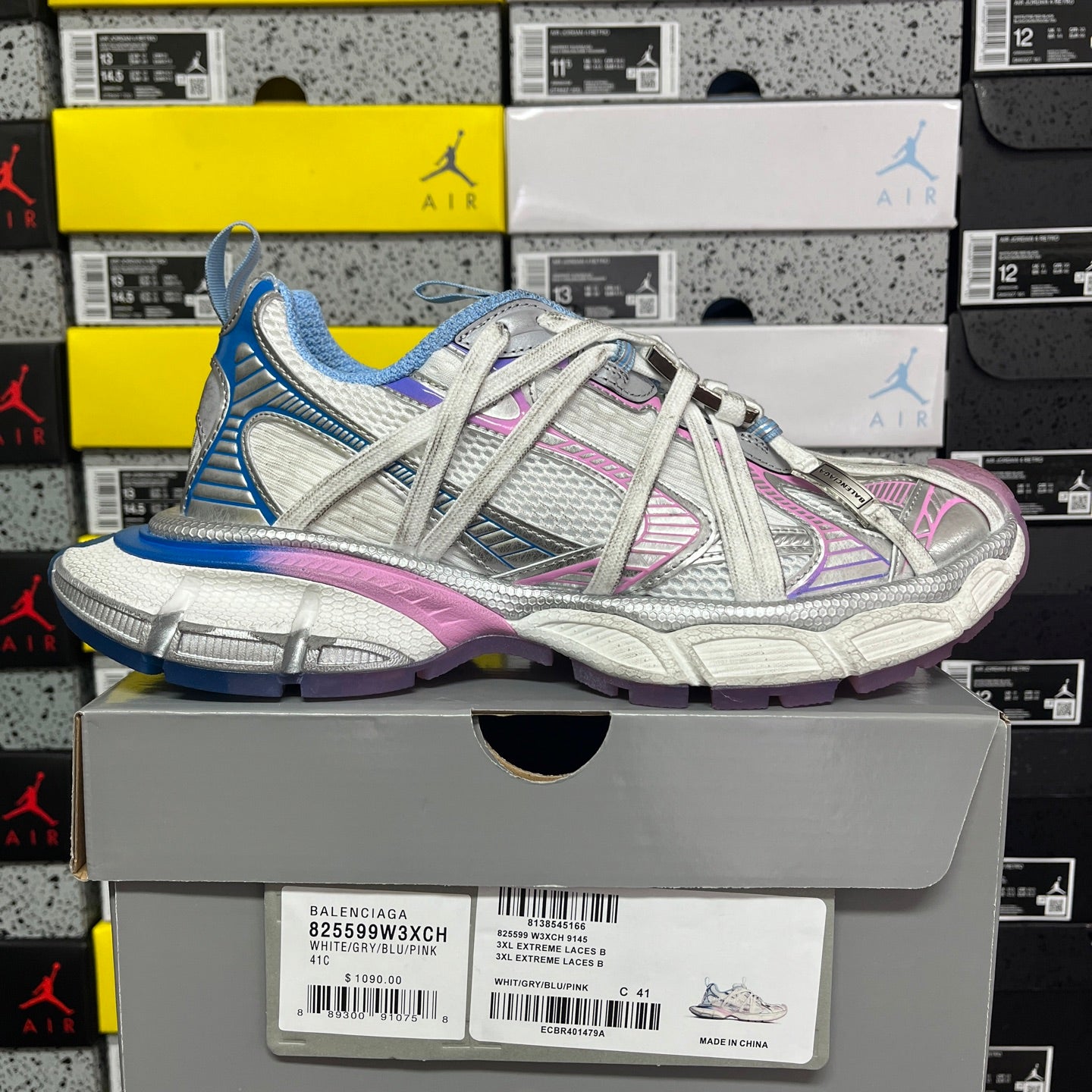Lace-up sneaker with white base, blue upper, pink accents, and chunky gray sole