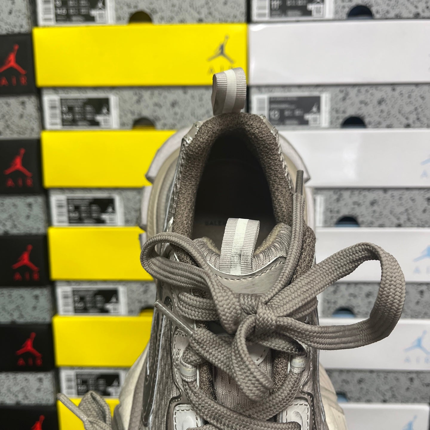 Gray sneaker back view with padded tongue, lace-up closure, and textured collar lining