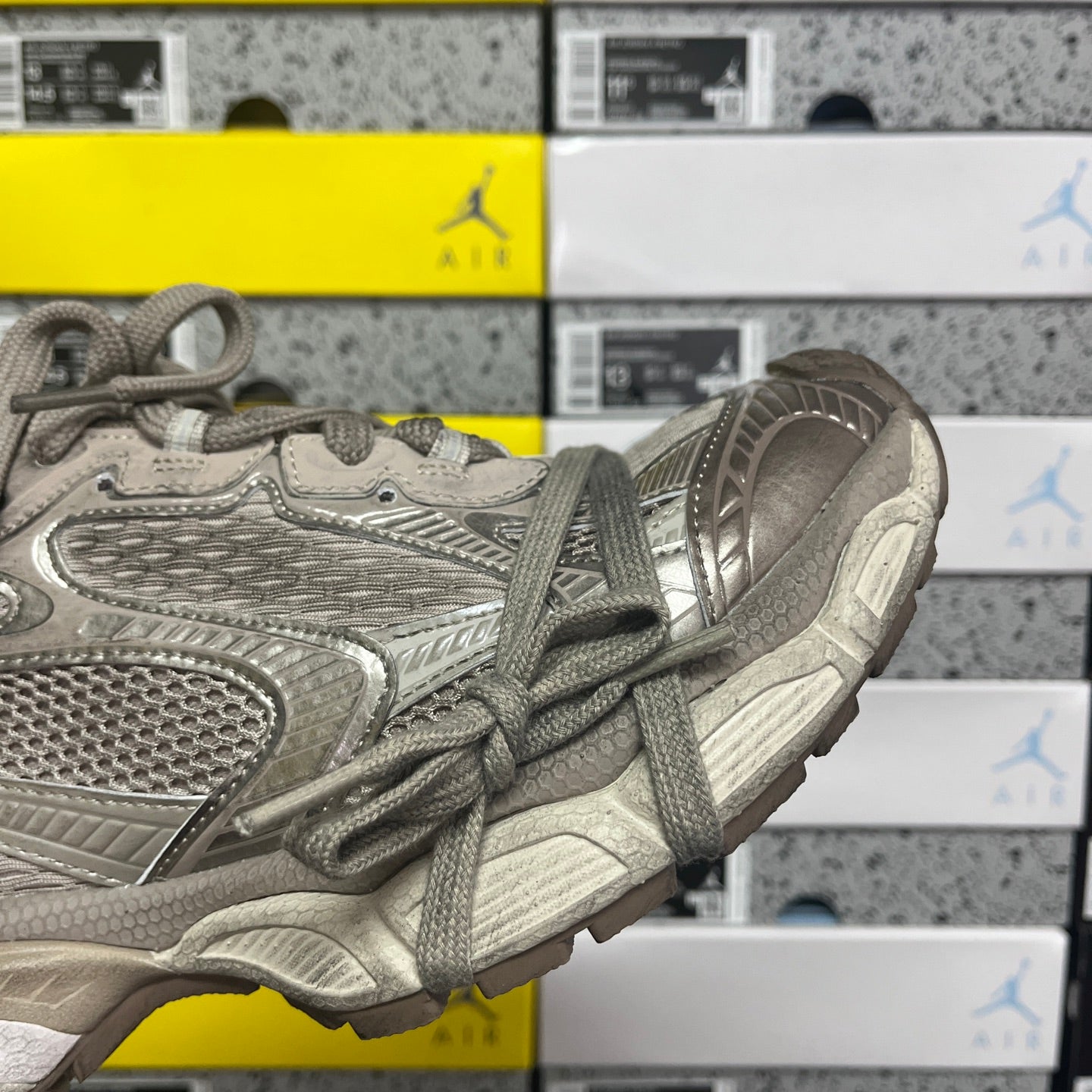 Gray lace-up sneaker side view with perforated-looking paneling and thick midsole