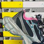 Unisex running shoe angled view with pink collar, black upper, and turquoise accents