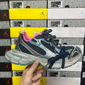 Unisex running shoe in black mesh with pink collar and turquoise side accents