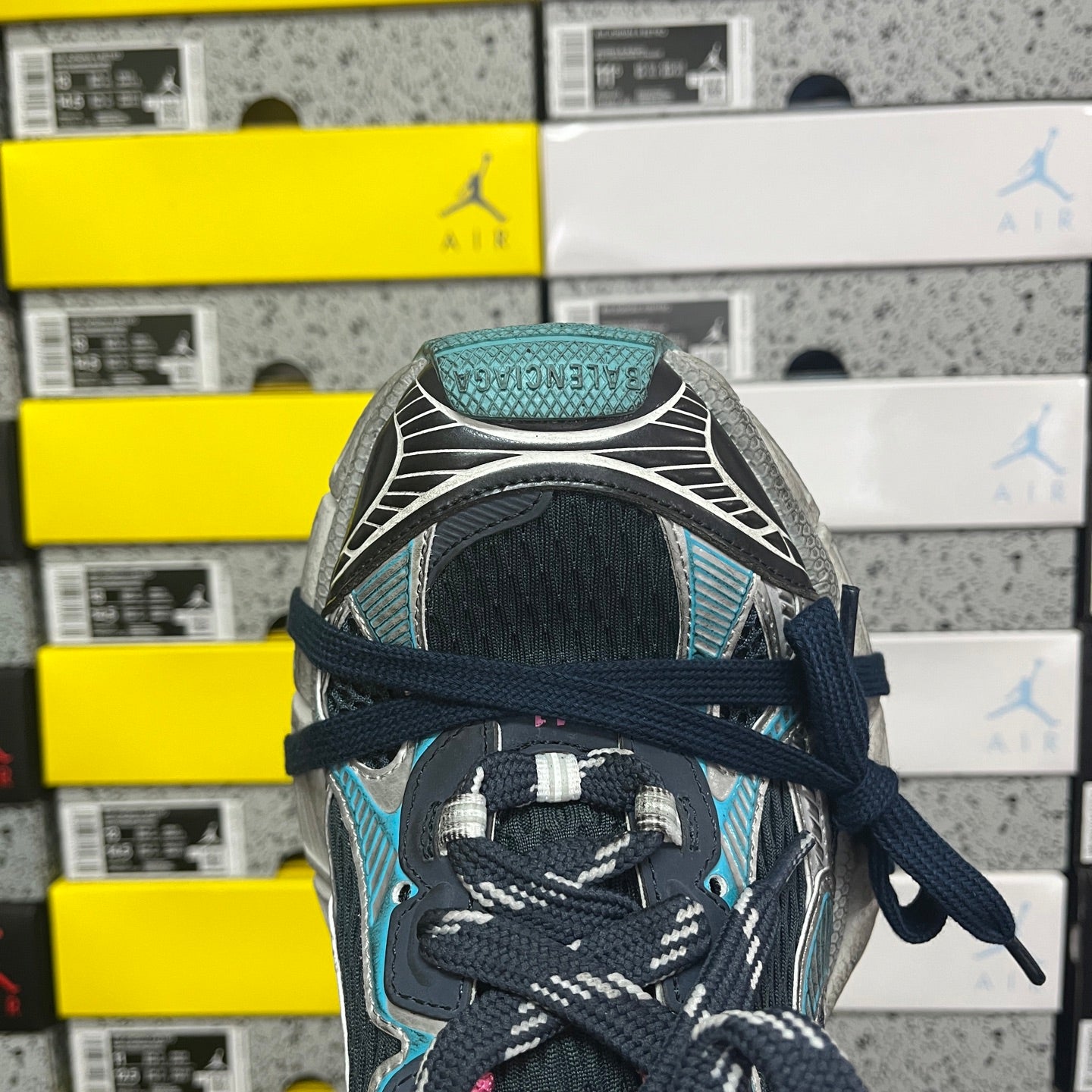 Unisex running shoe toe and lace area in black with turquoise and pink details