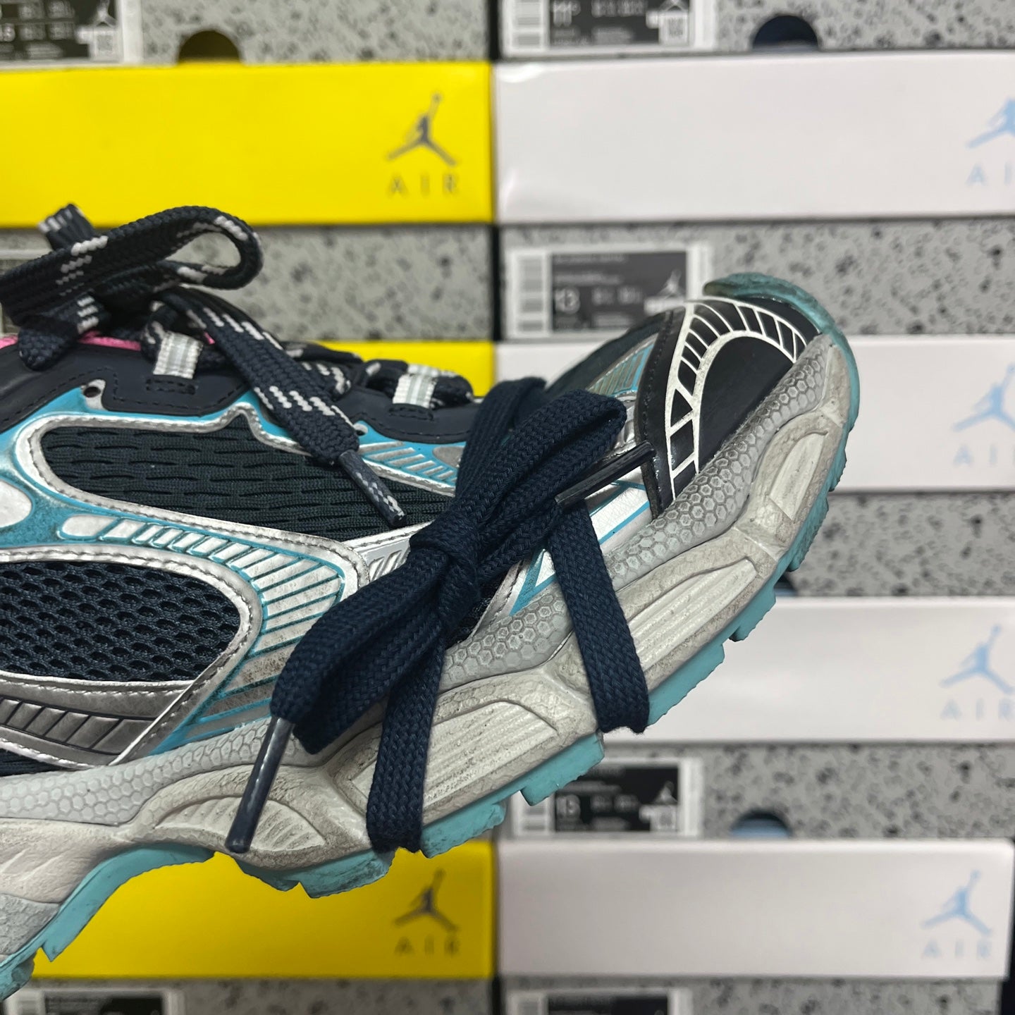 Unisex running shoe side view with dark laces, turquoise trim, and light sole